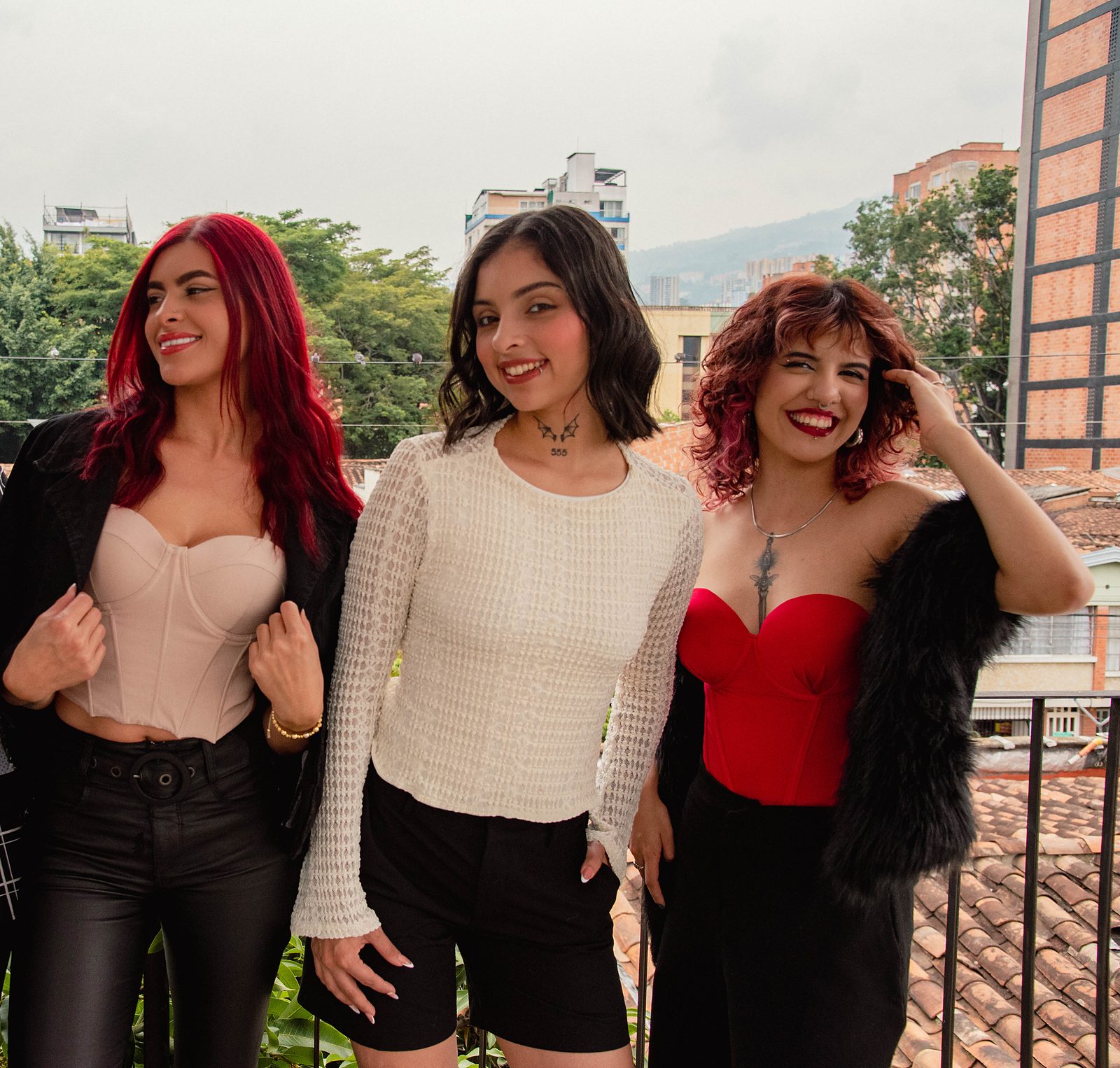 Tres creadoras sonríen en la terraza del estudio, con Medellín de fondo